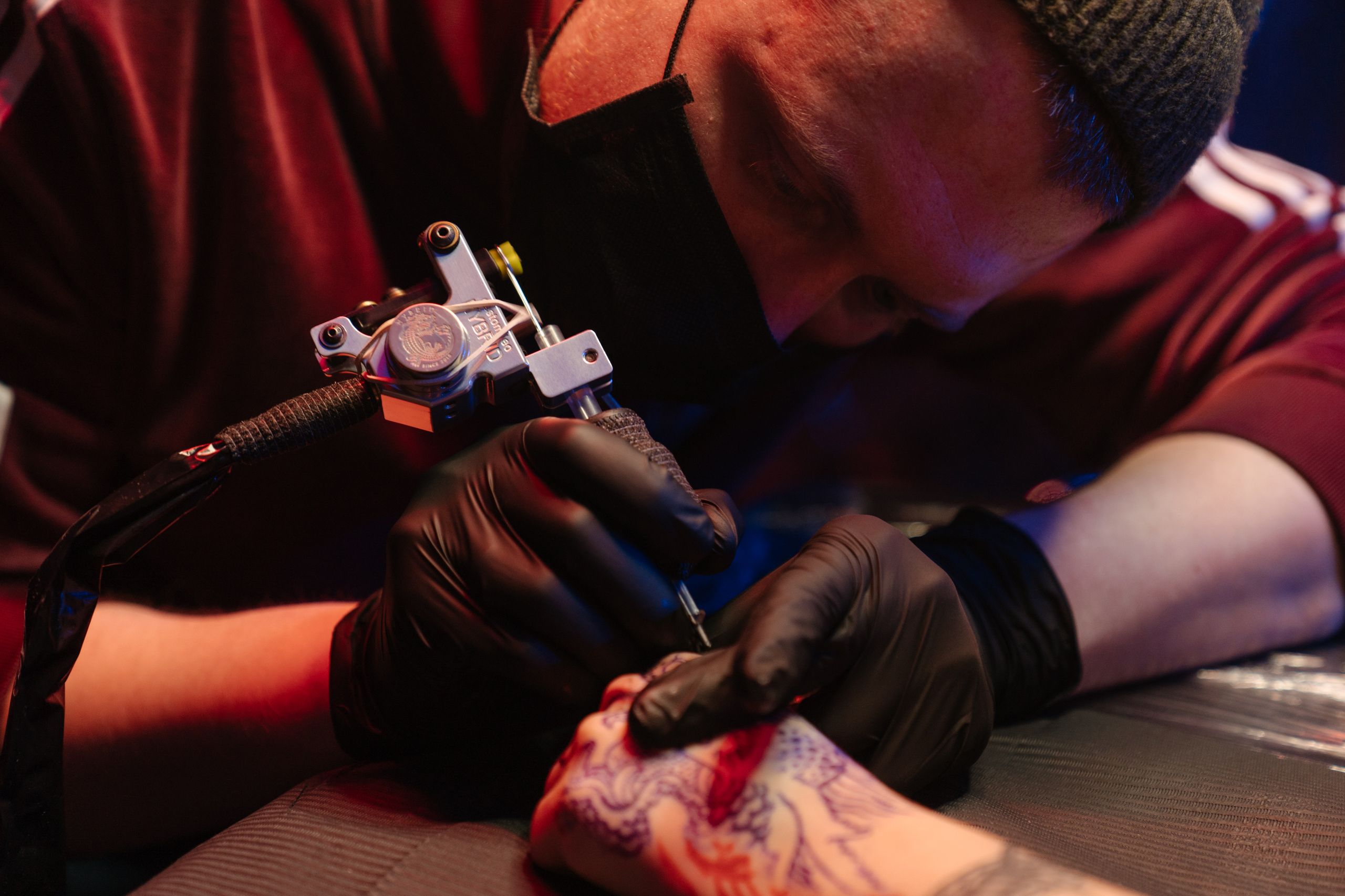 Tattoo artist working with a client