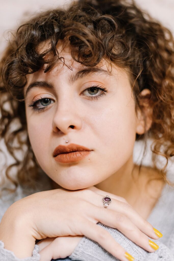 Close-up portrait of a curly-haired woman posing with a neutral expression in Istanbul.